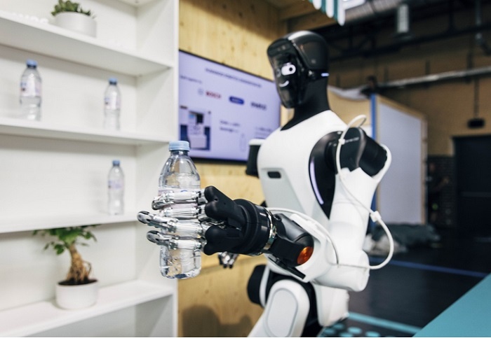 humanoidalny robot trzyma butelkę