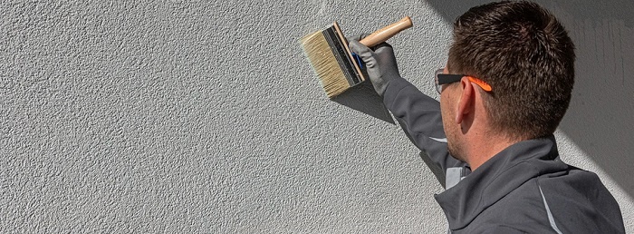 pędzel rozprowadzjący farbę na ścianie
