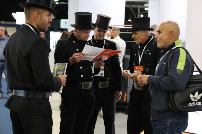grupa kominiarzy w kapeluszach na targach