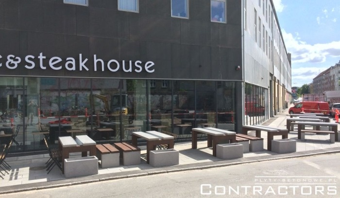 donice betonowe przed nowoczesnym budynkiem z restauracją